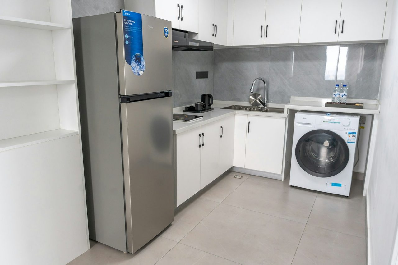 Household top-mount refrigerator with solid PU-foam-insulated door installed in a kitchen — typical end-use of doors foamed on this line